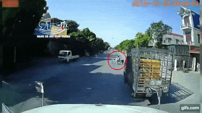 Chiếc xe container t&ocirc;ng tr&uacute;ng cụ &ocirc;ng đi xe m&aacute;y sang đường