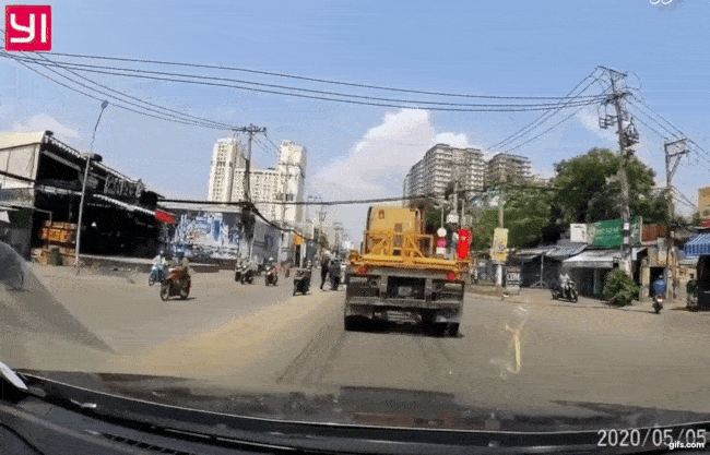 Khoảnh khắc người đ&agrave;n &ocirc;ng bị nam thanh ni&ecirc;n đấm tr&uacute;ng, ng&atilde; ra đằng sau, đ&uacute;ng l&uacute;c chiếc xe container chạy đến