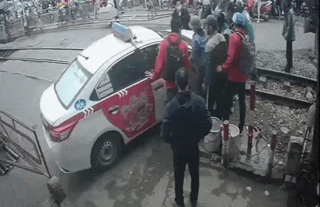 Người dân hợp sức đẩy chiếc taxi lùi lại phía sau