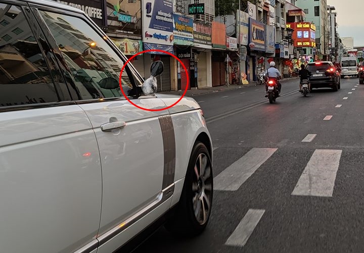 Xe Range Rover di chuyển tại Sài thành trong chiều mùng 2 Tết sử dụng gương của xe máy
