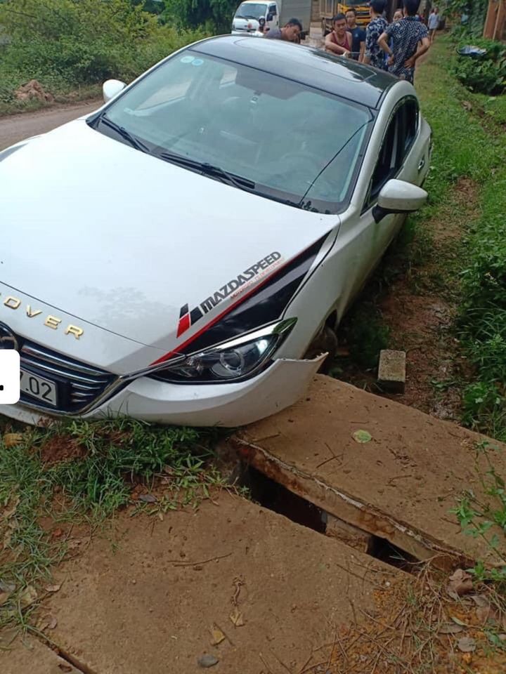 Chiếc ô tô Mazda tông trúng lối đi vào nhà dân, bắc qua rãnh thoát nước