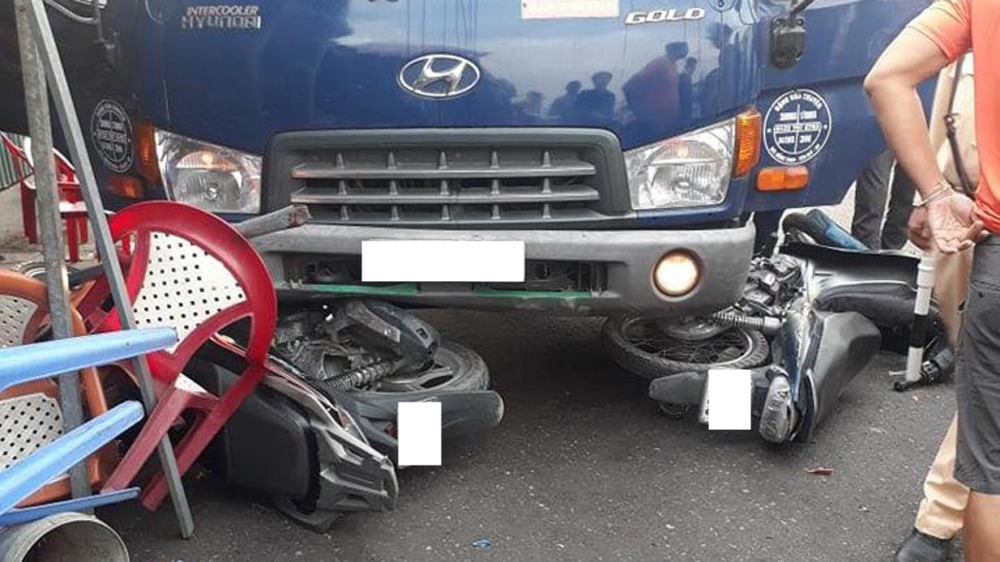 Hai chiếc xe máy bị cuốn dưới gầm xe tải