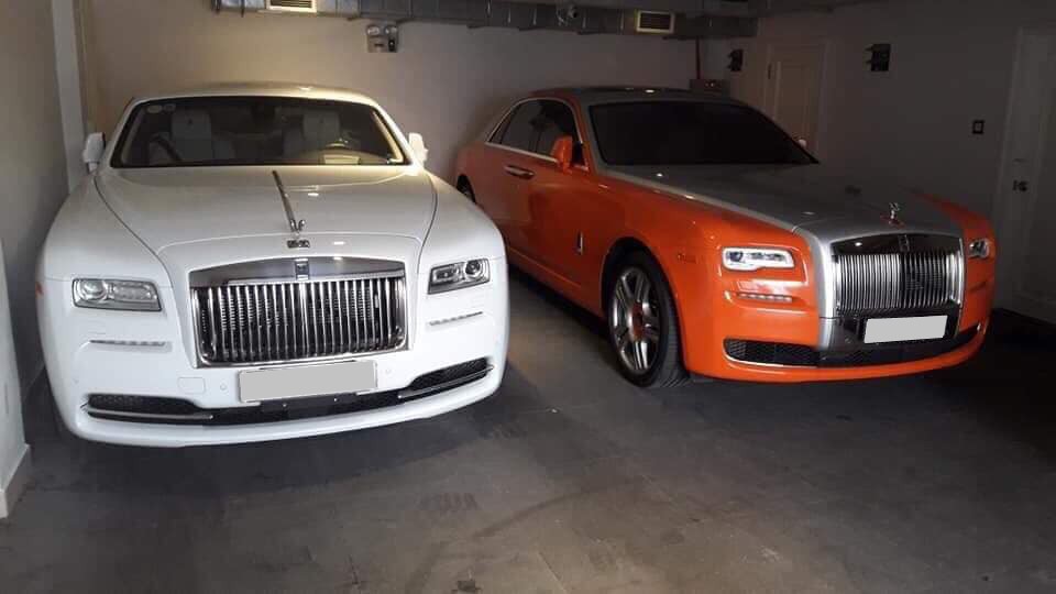Rolls-Royce Wraith bên trái lúc mang màu sơn nguyên bản là trắng và kế bên là Rolls-Royce Ghost Series II được dán đề-can sang màu cam-bạc